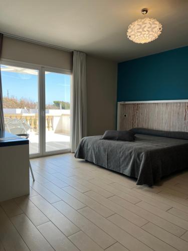 a bedroom with a bed and a blue wall at Tabù Hotel in Porto Cesareo