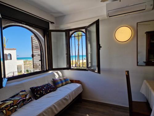 a living room with a couch and two windows at BeachSide Apartments Peñiscola in Peniscola
