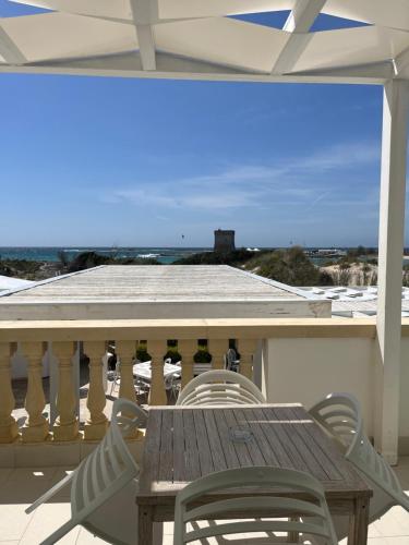 a table and chairs on a balcony with a view of the ocean at Tabù Hotel in Porto Cesareo