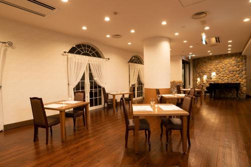 un restaurante con mesas y sillas de madera y un piano en Hashidate Bay Hotel, en Yosano