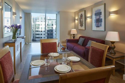 - un salon avec une table et un canapé dans l'établissement Marlin Apartments London Bridge - Empire Square, à Londres