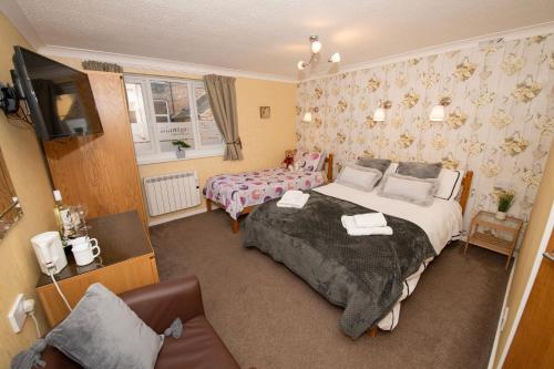 Habitación de hotel con cama y sofá en Blantyre Guest House, en Bridlington