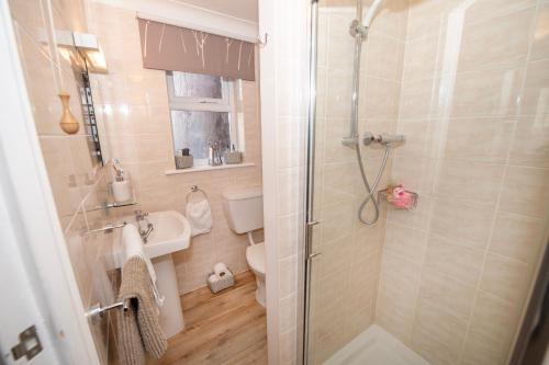 a bathroom with a shower and a toilet and a sink at Blantyre Guest House in Bridlington
