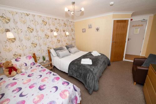 a hotel room with a bed and a couch at Blantyre Guest House in Bridlington