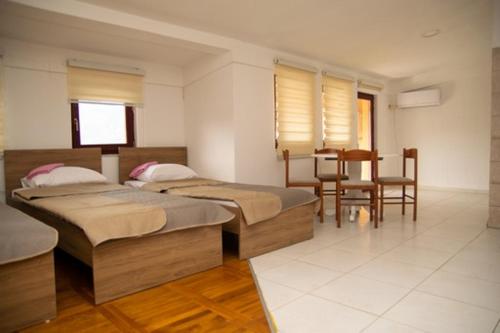 a bedroom with two beds and a table and chairs at SARAH APARTMENTS in Gusinje
