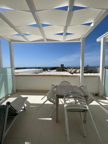 a patio with a table and chairs on a balcony at Tabù Hotel in Porto Cesareo