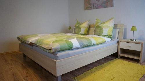 a bedroom with a bed with a yellow and green comforter at Ferienwohnung Einberger-Schinabeck in Grafenau