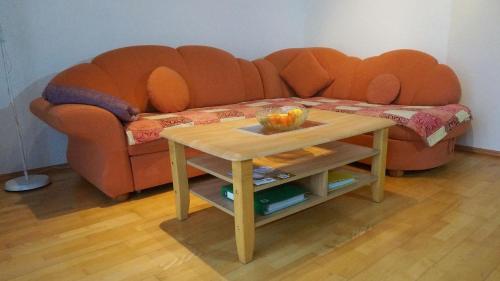 an orange couch with a table in front of it at Ferienwohnung Einberger-Schinabeck in Grafenau