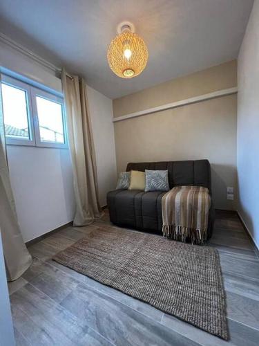 sala de estar con sofá negro y alfombra en Suite avec Spa Sukha Spa, en Vendres