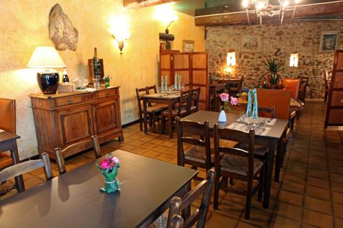 un restaurant avec des tables et des chaises avec des fleurs dessus dans l'établissement Logis Hotel Restaurant Auberge Du Peras, à Saint-Jean-du-Gard