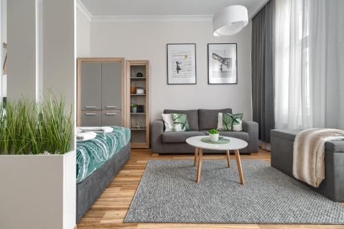 uma sala de estar com um sofá e uma mesa em Apartament Maya em Szczecin