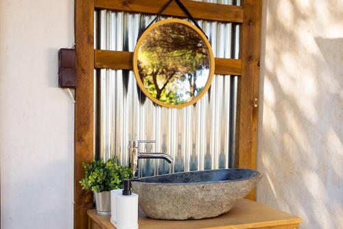 ein Badezimmer mit einem Steinwaschbecken und einem Spiegel in der Unterkunft Kampaoh Playa de Levante in Benidorm