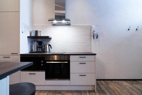 a kitchen with white cabinets and a stove top oven at Ski-Inn Kultakero in Pyhätunturi