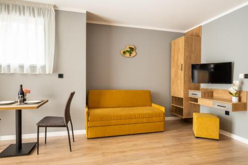 uma sala de estar com um sofá amarelo e uma mesa em Villa Pino em Velingrad