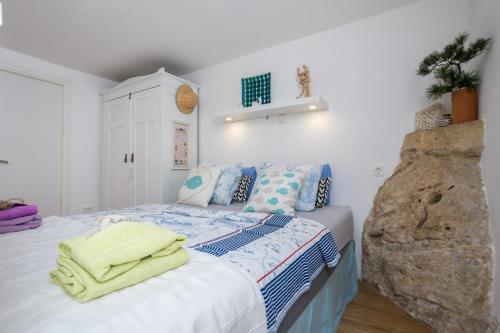 a bedroom with a bed with towels on it at Charming Studio apartment at House Rustica with terrace and nearby parking in Punat