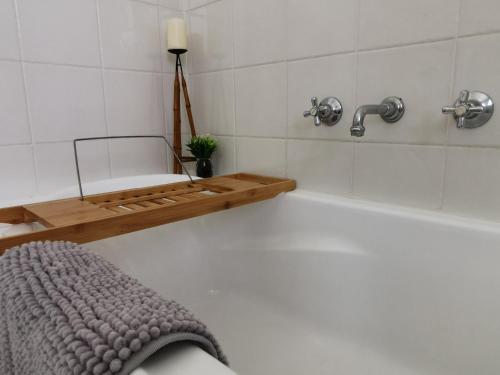 y baño con bañera y toalla. en Sydney Meets Miranda, Comfy 4 Bedrooms Corner House, en Miranda