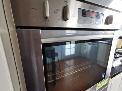 a microwave oven with its door open in a kitchen at Sydney Meets Miranda, Comfy 4 Bedrooms Corner House in Miranda