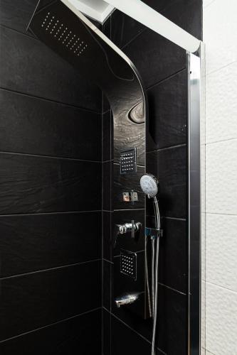 a black bathroom with a shower with a hose at Lovely 2BR w/ views over the river, parking incl in Vila Nova de Gaia