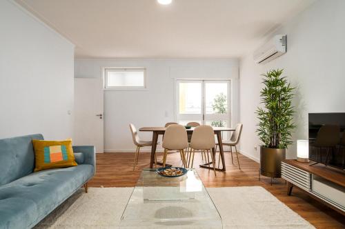 a living room with a blue couch and a table at Lovely 2BR w/ views over the river, parking incl in Vila Nova de Gaia