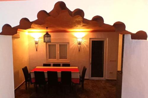 a dining room with a red table and chairs at Aladin Comfort Country T3 in Campinho