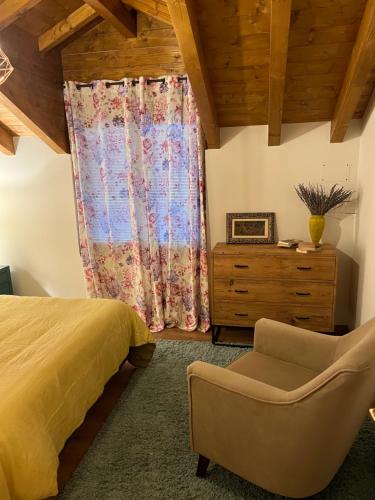 um quarto com uma cama, uma cadeira e uma cómoda em Los acebos el atico em Gallejones