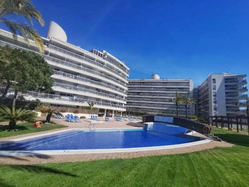 a large hotel with a swimming pool in front of a building at Seafront apartment in Blanes in Blanes