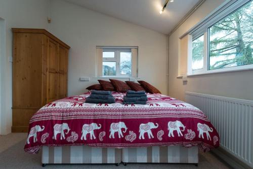 a bedroom with a large bed with a red blanket at Bristol self-catering studio+kitchen+parking in Bristol