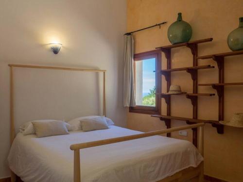 a bedroom with a bed and a window and shelves at Es Murteret, Grupo Mistral in Port des Canonge 