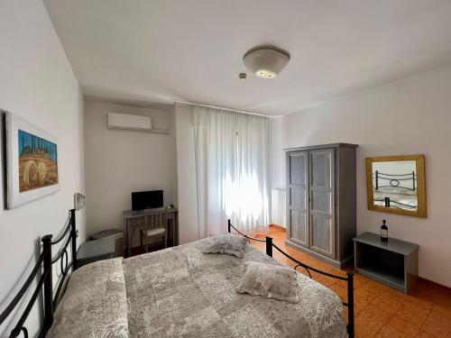 a bedroom with a bed and a television and a window at Hotel Marvin in Montepulciano