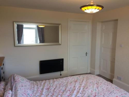 1 dormitorio con 1 cama y TV de pantalla plana en Beautiful Apartment in Character Former Rectory en Penrith