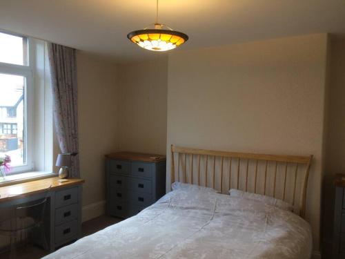 a bedroom with a bed and a dresser and a window at Beautiful Apartment in Character Former Rectory in Penrith