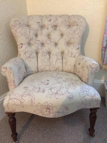 a white chair with flowers on it in a room at Beautiful Apartment in Character Former Rectory in Penrith