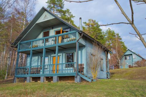 ein blaues Haus mit Balkon auf einem Hügel in der Unterkunft Rāznas Stāvkrasti in Kaunata