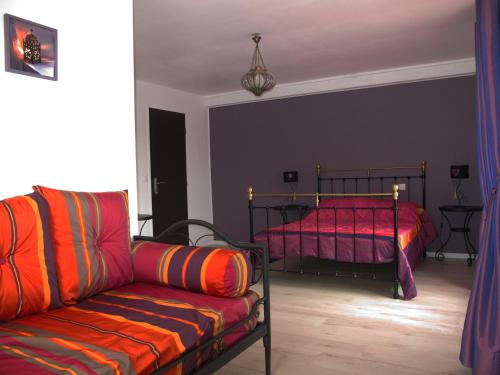 uma sala de estar com um sofá e uma cama em La Vigneraie de Meusnes em Meusnes