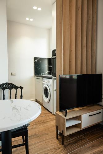 een woonkamer met een tv en een tafel bij Cozy and Chic Studio Apartment in Tirana