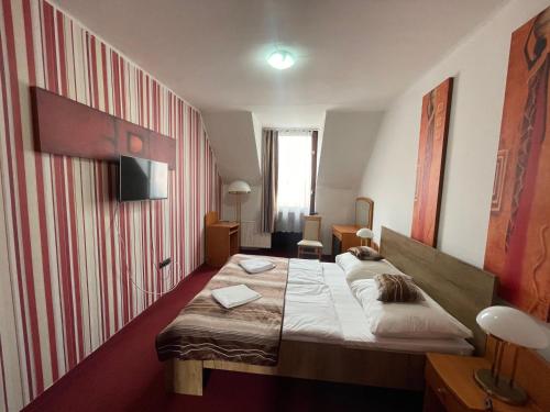 ein Hotelzimmer mit einem Bett in einem Zimmer in der Unterkunft Hotel Minaret&Étterem in Eger