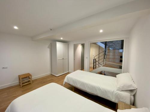- une chambre avec 2 lits et un escalier dans l'établissement Atahona 22, à Pontedeume