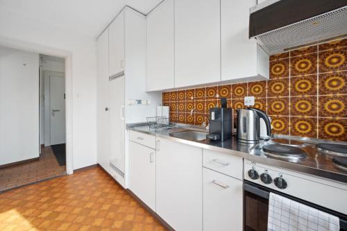 a kitchen with white cabinets and a stove at Muenstergasse Zurich Old Town in Zürich