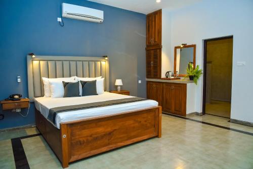 a bedroom with a bed and a blue wall at Katunayake Tectona Grandis in Negombo