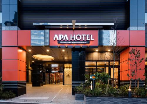 a building with a red hotel sign on it at APA Hotel Shinagawa Sengakuji Eki-Mae in Tokyo