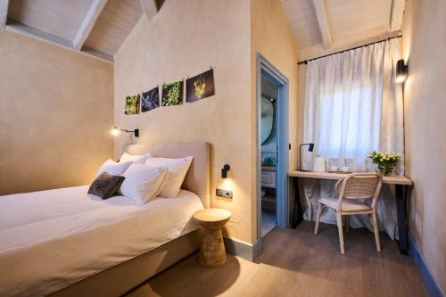 a bedroom with a bed and a desk and a window at Winery Cuj Bed & Breakfast in Vilanija