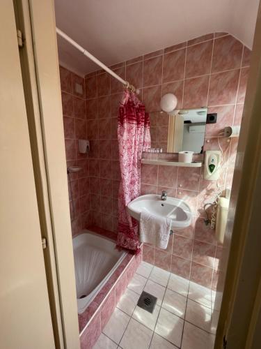 a bathroom with a bath tub and a sink at Hotel Minaret&Étterem in Eger