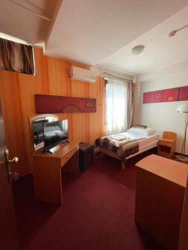 a hotel room with a bed and a television at Hotel Minaret&Étterem in Eger