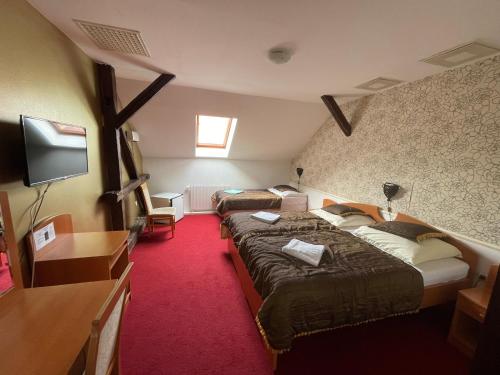 a hotel room with two beds and a flat screen tv at Hotel Minaret&Étterem in Eger