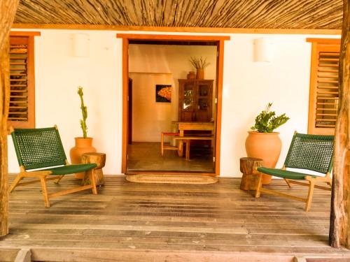 eine Veranda mit 2 Stühlen und einem Tisch in der Unterkunft Casa do CAMPO Atins com super Conforto in Atins