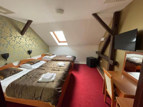 a hotel room with two beds and a television at Hotel Minaret&Étterem in Eger