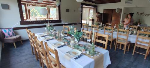 uma sala de jantar com mesas e cadeiras brancas em Le Rookie Mountain em Le Grand-Bornand