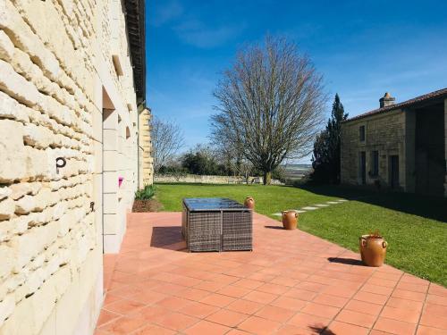 a brick patio with a trash can next to a building at Gîte Au Boom Coeur - petit déjeuner inclus - SPA en option in Tourtenay