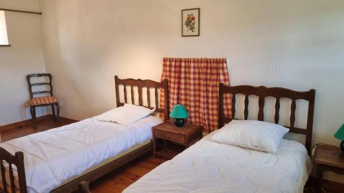 1 dormitorio con 2 camas y mesa con lámpara en L'Oustalou - Maison-Jardin-Wifi en Villeneuve