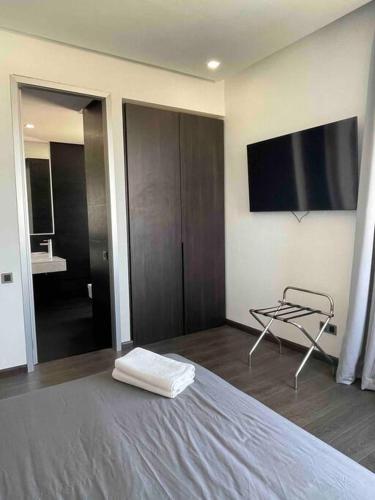 a bedroom with a bed and a tv on the wall at Luxury Palm Villa in Marrakech